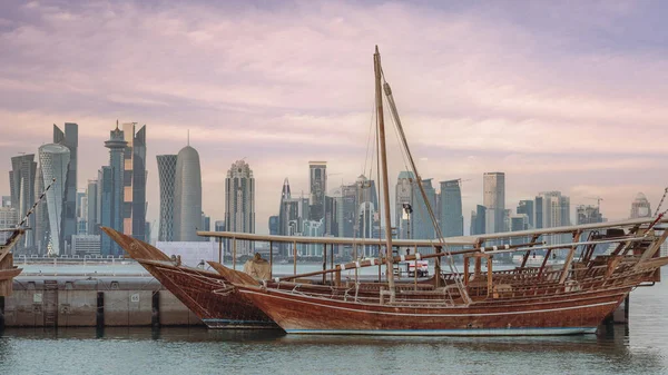 Doha, Qatar- August 05,2022: traditional dhows at Qatar corniche, with Qatar skyline in the background