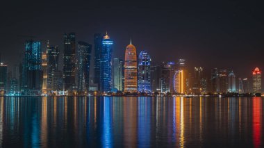 Doha, Katar - Eylül 09.2022: Doha şehir merkezinin gece boyunca pek çok iş kulesi ile canlı bir silueti.