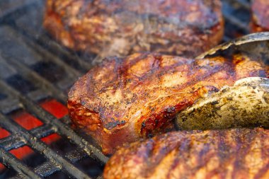 Alevli ızgarada ızgara biftekler ve seçici bir odaklanma ile vurulma. Arka bahçede ızgara. Taze biftek. kaburga bifteği.