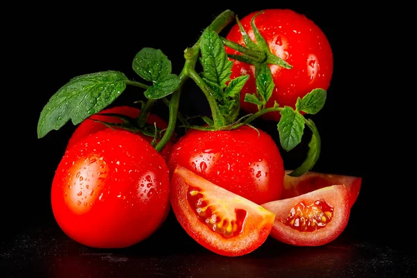 Reife Bio-Tomaten auf dem schwarzen Tisch mit Wassertropfen — Stockfoto