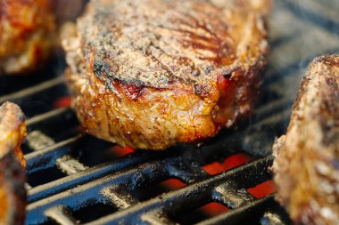 Alevli ızgarada ızgara biftekler ve seçici bir odaklanma ile vurulma. Arka bahçede ızgara. Taze biftek. kaburga bifteği.