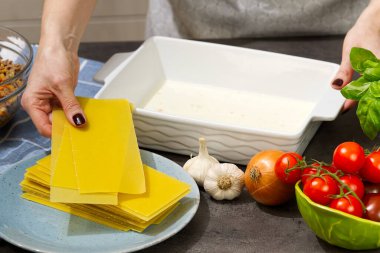 Kadın mutfakta lazanya hazırlıyor. Lazanya tarifi - İtalyan yemeği