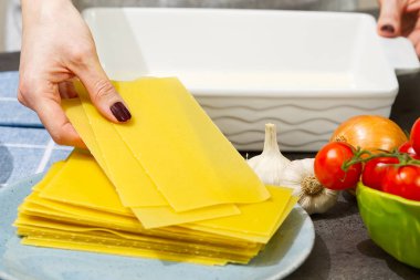 Kadın mutfakta lazanya hazırlıyor. Lazanya tarifi - İtalyan yemeği