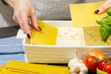 Kadın mutfakta lazanya hazırlıyor. Lazanya tarifi - İtalyan yemeği