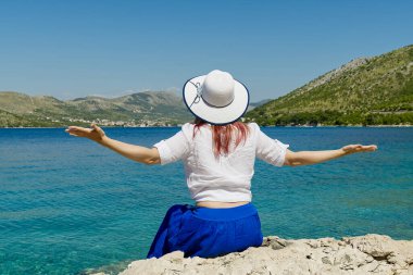 Mutlu güzel genç kadın özgürlüğün ve deniz manzarasının tadını çıkarıyor, yaz tatilinin.