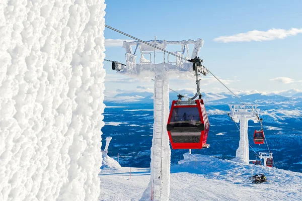 Rote Seilbahn in einem Skigebiet in den Alpen. Rote Gondelbahn in einem Skigebiet, Schweden, frostiger sonniger Tag — Stockfoto