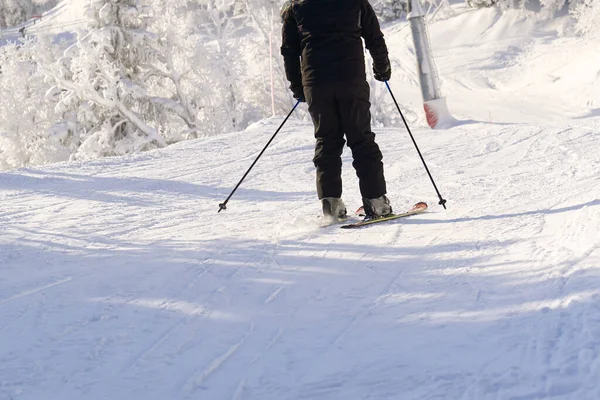 Esquiador em montanhas, piste preparado e dia ensolarado. inverno, lazer, esporte e conceito de pessoas — Fotografia de Stock