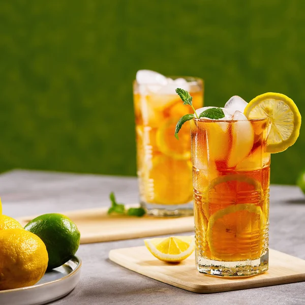 Холодный чай. Традиционный чай со льдом и лимоном в высоких стаканах — стоковое фото