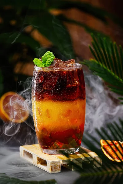 Hummel-Kaffee mit Eis auf dunklem tropischen Hintergrund. Espresso, Orangensaft und Sirup in Schichten — Stockfoto