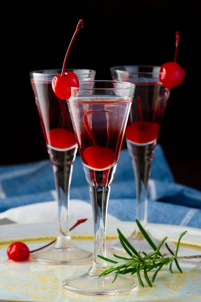 Licor de cereza y cóctel de vodka con bayas en la mesa de madera. —  Fotos de Stock