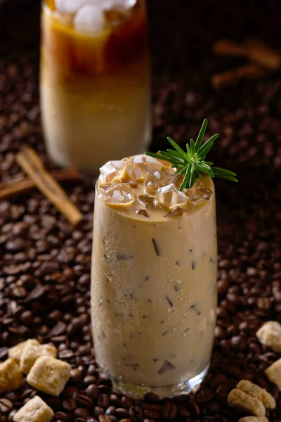 Café helado con leche. Taza de café con leche helada, té con leche sobre fondo de semillas de café oscuro —  Fotos de Stock
