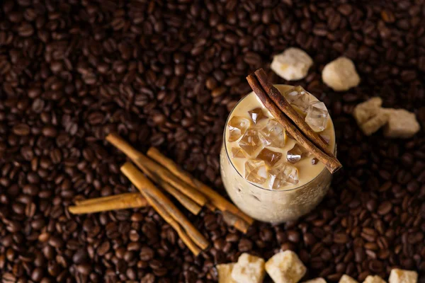 Café helado con leche. Taza de café con leche helada, té con leche sobre fondo de semillas de café oscuro —  Fotos de Stock