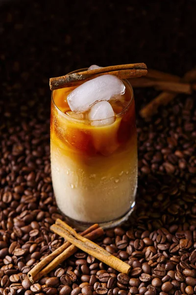 Café helado con leche. Taza de café con leche helada, té con leche sobre fondo de semillas de café oscuro —  Fotos de Stock