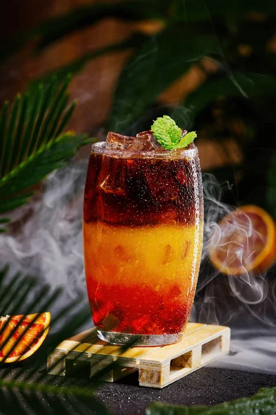 Hummel-Kaffee mit Eis auf dunklem tropischen Hintergrund. Espresso, Orangensaft und Sirup in Schichten — Stockfoto