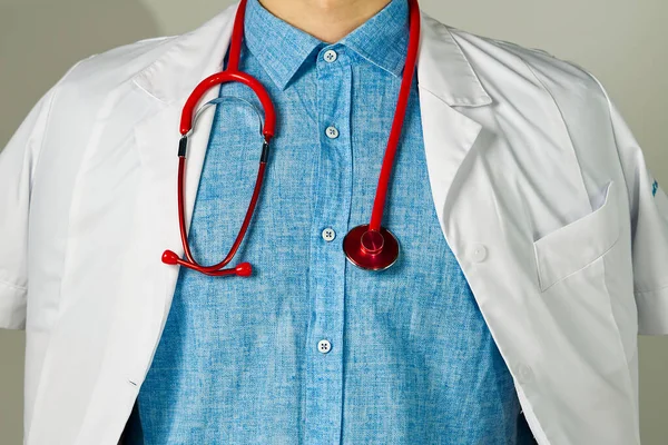 Onherkenbare jongeman arts staan over lichte achtergrond — Stockfoto