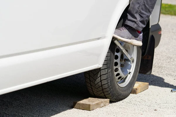 Tamirci araba lastiğini aletle değiştiriyor. Yol yardımı, lastik değiştirme ve onarım, tekerlek. — Stok fotoğraf
