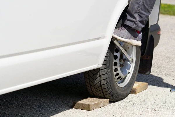 Mechanic changing car tire with tool. road help, changing and repairing tire, wheel.