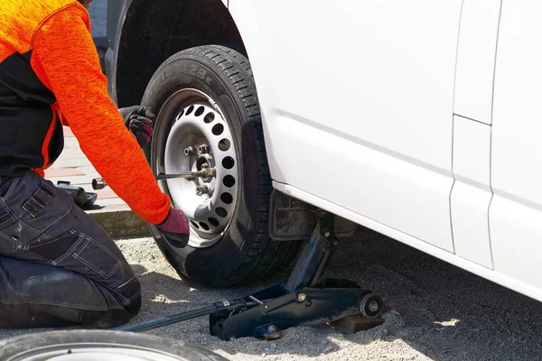 Meccanico cambio gomme auto con utensile. aiuto stradale, cambio e riparazione pneumatici, ruota. — Foto Stock