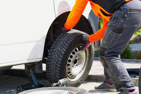 Tamirci araba lastiğini aletle değiştiriyor. Yol yardımı, lastik değiştirme ve onarım, tekerlek. — Stok fotoğraf