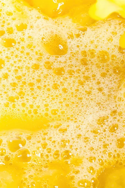 Closeup of splashing orange juice, top view. Splash of fresh sweet orange, mango, fruit juice. Freeze motion of pouring orange juice .