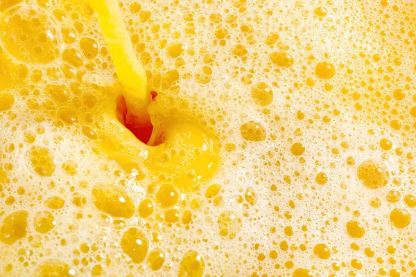 Closeup of splashing orange juice, top view. Splash of fresh sweet orange, mango, fruit juice. Freeze motion of pouring orange juice .