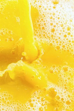 Portakal suyuna yakın çekim, üst manzara. Bir tutam taze portakal, mango, meyve suyu. Portakal suyunun dondurucu hareketi .