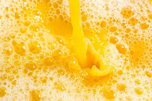 Closeup of splashing orange juice, top view. Splash of fresh sweet orange, mango, fruit juice. Freeze motion of pouring orange juice .