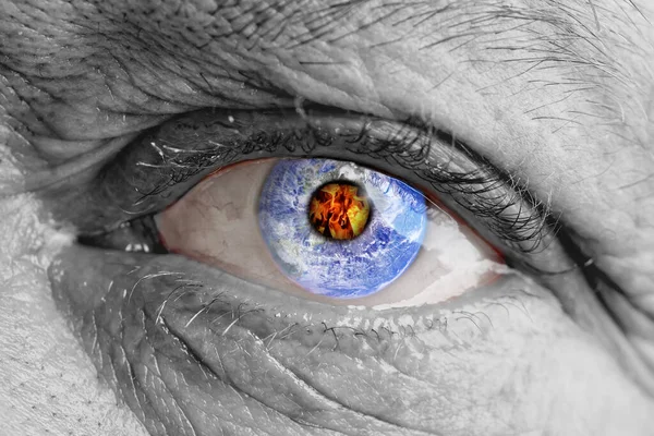 The earth globe inside of a mans eye. the concept of the destruction of the earth in the human eye. death of the planet due to an atomic explosion or nuclear strike