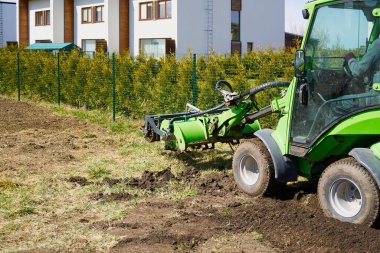 Traktör tarladaki toprağı işliyor. Eski ekinlerden toprak öğütüyoruz. Toprak kalitesini yumuşatmak ve iyileştirmek. Çiftçilik. Toprak çalışmalarına hazırlık. Tarım tarım sektörü