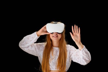 Young woman wearing VR glasses and interacting with virtual reality, entertainment, education and innovative technology concept. goggles to interact with metaverse