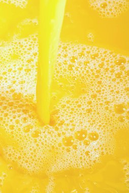 Portakal suyuna yakın çekim, üst manzara. Bir tutam taze portakal, mango, meyve suyu. Portakal suyunun dondurucu hareketi .