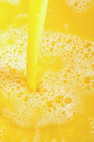 Closeup of splashing orange juice, top view. Splash of fresh sweet orange, mango, fruit juice. Freeze motion of pouring orange juice .