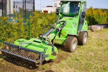 Traktör tarladaki toprağı işliyor. Eski ekinlerden toprak öğütüyoruz. Toprak kalitesini yumuşatmak ve iyileştirmek. Çiftçilik. Toprak çalışmalarına hazırlık. Tarım tarım sektörü