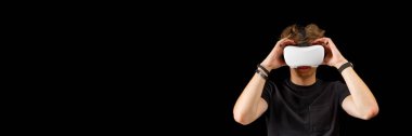 Portrait of a young man with 3D virtual reality glasses. Young man using white virtual reality headset, VR, future, goggles, technology concept on black background.