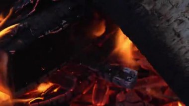 Büyük kütüklerden alevler. Sıcak şenlik ateşi, şömine barbeküye hazır. Şenlik ateşi yakın çekim. Açık hava yangını