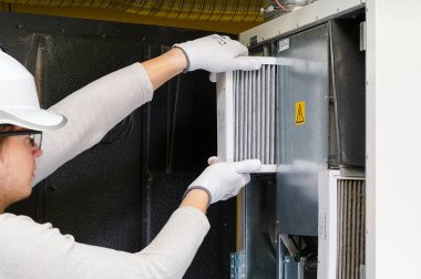 Hvac filtresi ev merkezi havalandırma sistemini değiştiriyor. Askerler fırında filtre değiştiriyor. Döner ısı dönüştürücüdeki filtreyi değiştir.