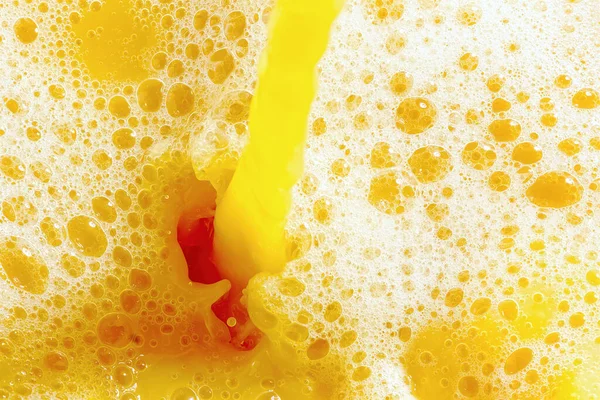 Closeup of splashing orange juice, top view. Splash of fresh sweet orange, mango, fruit juice. Freeze motion of pouring orange juice .