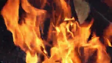 Büyük kütüklerden alevler. Sıcak şenlik ateşi, şömine barbeküye hazır. Şenlik ateşi yakın çekim. Açık hava yangını