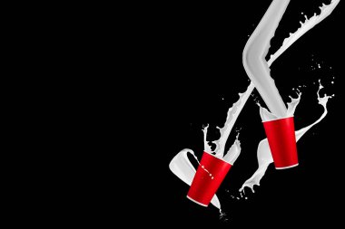 Siyah arka planda süt lekeleri olan kağıt bardaklar. Tek kullanımlık bardakta beyaz süt sıçraması. Tasarım için hazır. maketleme