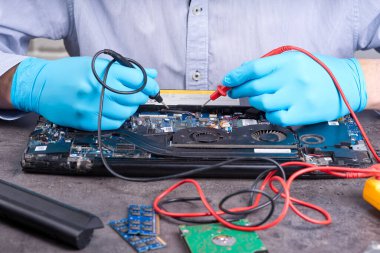 Bilgisayarın anakart veya dizüstü bilgisayarını tamir eden eller hizmete hazır olsun. Laptop tamir servisi. Bilgisayar donanım güncellemesi ve bakımı. Mühendis bozuk defteri tamir ediyor.