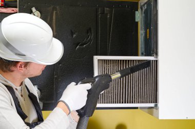 Hvac filtresi ev merkezi havalandırma sistemini değiştiriyor. Askerler fırında filtre değiştiriyor. Döner ısı dönüştürücüdeki filtreyi değiştir.
