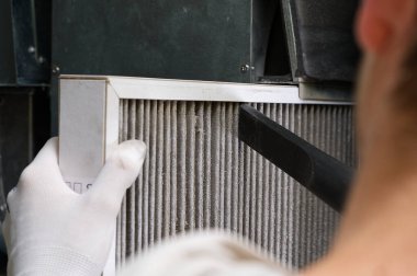 hvac filtresi değiştiriliyor. Merkezi havalandırma sistemindeki filtreyi değiştiriyorum, fırın. Ev merkezi klima sistemi için Kirli Hava filtresi değiştiriliyor. Döner ısı değiştiricideki filtreyi değiştir