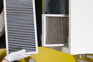 hvac filtresi değiştiriliyor. Merkezi havalandırma sistemindeki filtreyi değiştiriyorum, fırın. Ev merkezi klima sistemi için Kirli Hava filtresi değiştiriliyor. Döner ısı değiştiricideki filtreyi değiştir