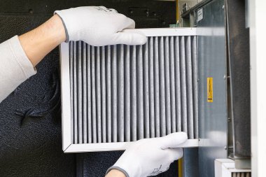 hvac filtresi değiştiriliyor. Merkezi havalandırma sistemindeki filtreyi değiştiriyorum, fırın. Ev merkezi klima sistemi için Kirli Hava filtresi değiştiriliyor. Döner ısı değiştiricideki filtreyi değiştir