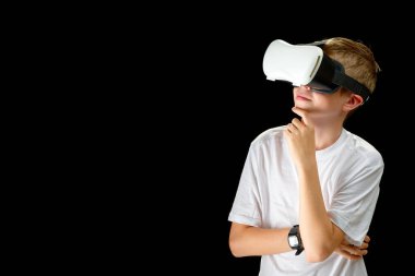 Portrait of young Boy playing VR game in black background. Young hipster wearing VR headset, half body shot. Young generation choose virtual reality, metaverse relaxation concept. remote education