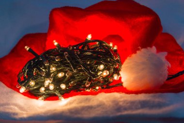 Rio de Janeiro 'da beyaz arka planda kırmızı şapkalı Noel dekoratif ışıkları.