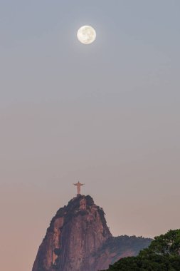 Kurtarıcı İsa ve Ay Rio de Janeiro, Brezilya 'da - 19 Mart 2022: Rio de Janeiro' daki Kurtarıcı İsa heykelinin yanında Ay batıyor.