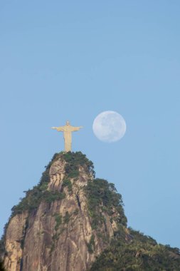 Kurtarıcı İsa ve Brezilya, Rio de Janeiro 'da dolunay - 18 Nisan 2022: Rio de Janeiro' daki Kurtarıcı İsa heykelinin yanında dolunay.