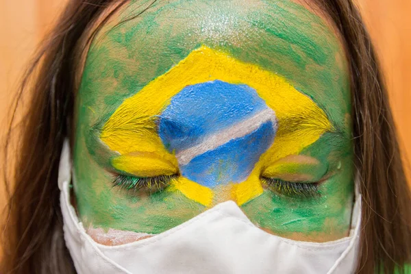 顔をブラジルの国旗で描いたマスクをした子供は — ストック写真