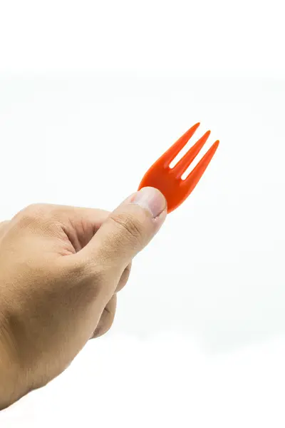 Mão com garfo laranja isolado em branco — Fotografia de Stock